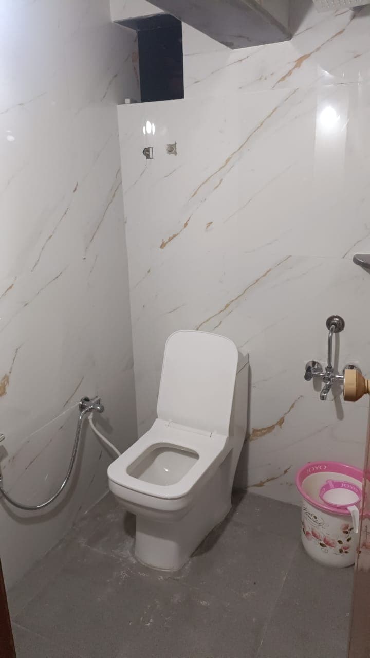 Clean marble-tiled attached bathroom